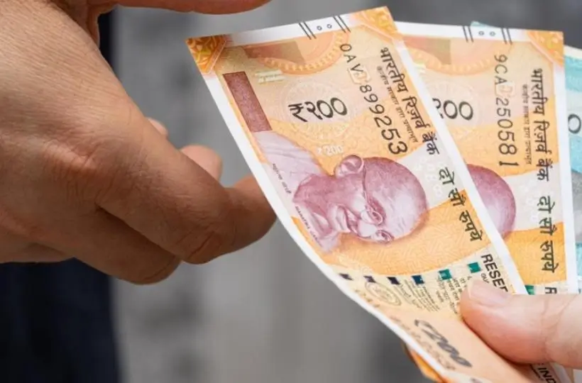 Hands exchanging Indian ₹200 notes